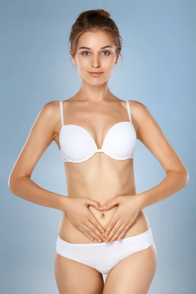 Woman health problem. Closeup of female with fit slim body in panties and bra suffering from pain and holding her hands on the stomach. Digestive disorders, period pain, health issues concept — Stock Image Woman Health Problem Closeup Female Fit Slim Body Panties Bra Stock Photo