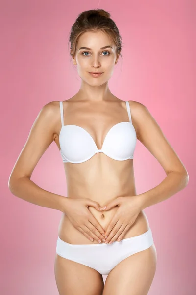 Woman health problem. Closeup of female with fit slim body in panties and bra suffering from pain and holding her hands on the stomach. Digestive disorders, period pain, health issues concept — Stock Image Woman Health Problem Closeup Female Fit Slim Body Panties Bra Stock Photo