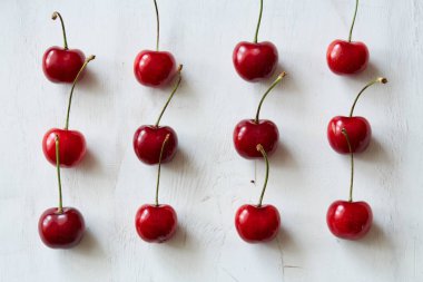 Dağınık tatlı kiraz kopya alanı ile beyaz vintage arka planda. Doku veya arka plan görüntüsü. Vegan rasyon, sağlıklı doğal beslenme, çiğ gıda katkı maddeleri ve pişirme