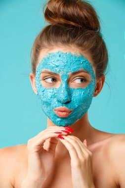 Beauty treatment - woman applying clay face mask clipart