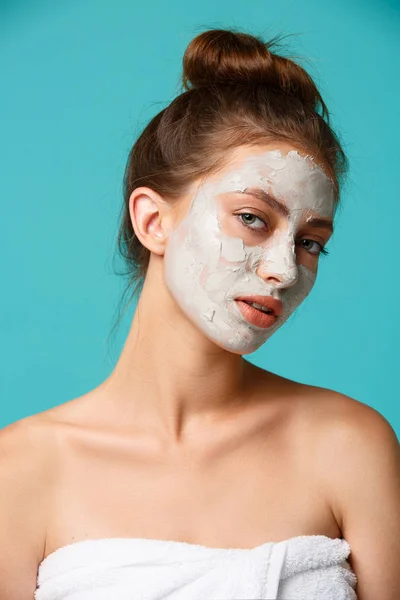 Beauty treatment - woman applying clay face mask — Stock Photo, Image