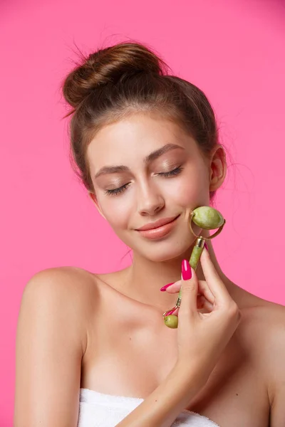 Yüzüne masaj yaptığı için yeşim takla atan bir kadın.