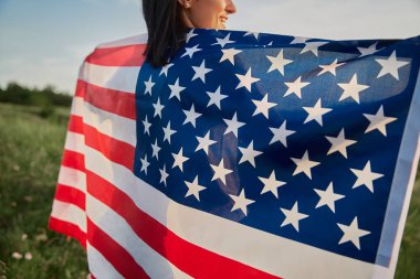 4 Temmuz. 4 Temmuz 'da. Amerikan bayrağıyla güzel bir simgeye karşı Amerikan bayrağı taşıyan bir kadın. Bağımsızlık Günü. Güzel gün batımı ışığı. Vatansever bayram, demokrasi saygı ve gazi saygı kavramı