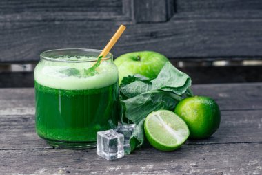 Kırsal ahşap masada cam ve lahana yapraklı yeşil elma püresi. Yaz Detox sallama arkaplanı