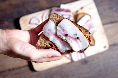 Tahtada ve elde siyah ekmek olan domuz yağı.