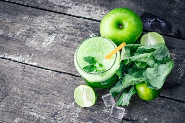 Kırsal ahşap masada cam ve lahana yapraklı yeşil elma püresi. Yaz Detox sallama arkaplanı