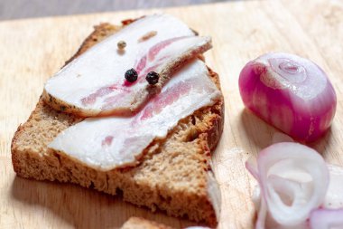Tahtada siyah ekmek ve soğan olan domuz yağı..