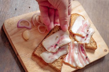 Tahtada ve elde siyah ekmek olan domuz yağı.