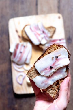 Tahtada ve elde siyah ekmek olan domuz yağı.