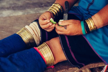 Geleneksel kostümde uzun boyunlu kadın elleri ve bacakları. Tayland kabile köyü. Bacaklarda geleneksel bilezikler.