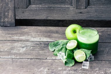 Kırsal ahşap masada cam ve lahana yapraklı yeşil elma püresi. Yaz Detox sallama arkaplanı