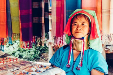 Uzun Boylu Kadın Tayland 'ın kuzeyindeki kabile köyünde evinin önünde kumaş dokuyordu..