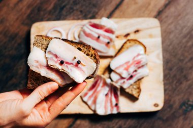 Tahtada ve elde siyah ekmek olan domuz yağı.