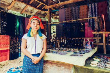 Uzun Boylu Kadın Tayland 'ın kuzeyindeki kabile köyünde evinin önünde kumaş dokuyordu..