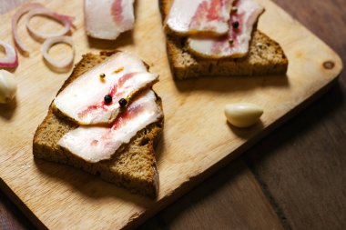 Tahtada siyah ekmek ve soğan olan domuz yağı..