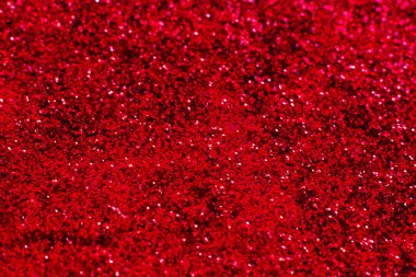 Kırmızı parıltılı doku. Şenlikli ışıl ışıl pullar arka planda yakın plan. Sevgililer günü, yeni yıl ve Noel tatilleri için parlak parlak duvar kağıtları..