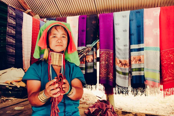 Uzun Boylu Kadın Tayland 'ın kuzeyindeki kabile köyünde evinin önünde kumaş dokuyordu..