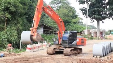 Chiangrai / Tayland - 20 Ağustos 2018, Hitachi turuncu kazıcısı, çimento halkası Chiangrai - Chiangmai yolu 118 'i hareket ettiren yolda çalışıyor.