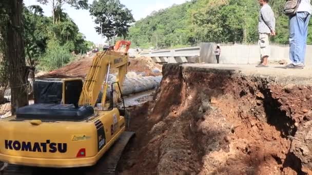 チェンライ 2018年8月20日 洪水後の道路の再建 黄色の掘削機が川で働いている 労働者とコンクリートパイプ チェンライ チェンマイロード118 — ストック動画