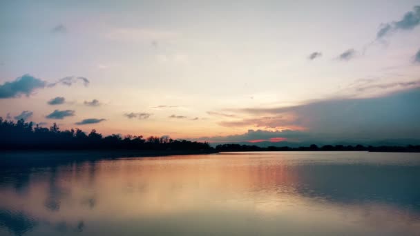Червоний захід сонця над озером. Червоне і рожеве небо з хмарами. Літній морський захід сонця. 4k Відео . — стокове відео