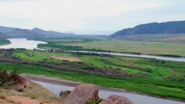 Été, jour, vue de la colline sur la rivière avec un rocher au premier plan. Bouriatie, la rivière Selenga.