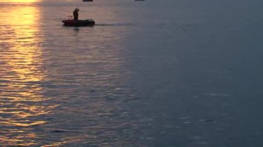 Erkekler açık denizde bir otobottan balık yakalıyorlar.