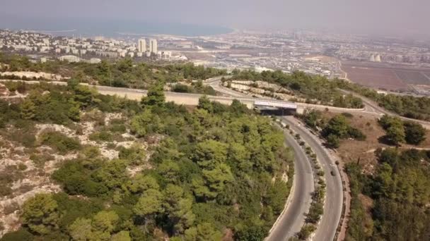 Survol d'un parc municipal près de l'université Technion. Arbres verts dans le centre de Haïfa. La ville et la mer en arrière-plan.