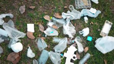 Çimlere saçılmış çöp yığını. Çevresel kirlilik kavramı. 4K video