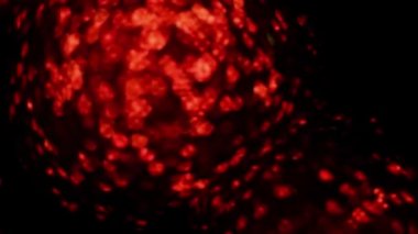 Soyut kırmızı arka planda ağır çekimde full HD görüntü yakıyor. Parlak doku karanlıkta yanar.