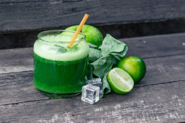 Kırsal ahşap masada cam ve lahana yapraklı yeşil elma püresi. Yaz Detox sallama arkaplanı