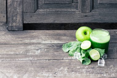 Kırsal ahşap masada cam ve lahana yapraklı yeşil elma püresi. Yaz Detox sallama arkaplanı