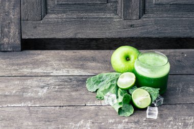 Kırsal ahşap masada cam ve lahana yapraklı yeşil elma püresi. Yaz Detox sallama arkaplanı