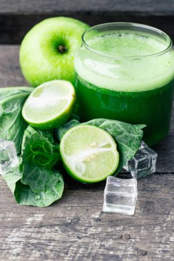 Kırsal ahşap masada cam ve lahana yapraklı yeşil elma püresi. Yaz Detox sallama arkaplanı