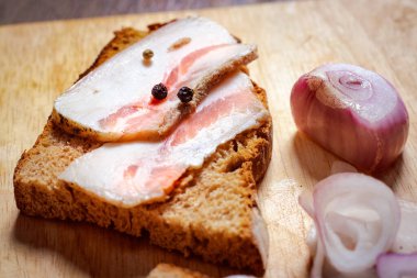 Tahtada siyah ekmek ve soğan olan domuz yağı..