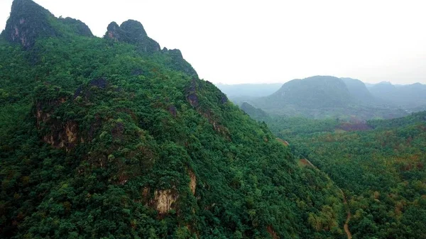 Hermoso amanecer sobre las montañas del bosque salvaje en la mañana en Laos. Vídeo aéreo sobrevolando montañas. —  Fotos de Stock