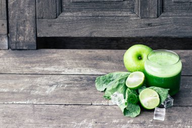 Kırsal ahşap masada cam ve lahana yapraklı yeşil elma püresi. Yaz Detox sallama arkaplanı