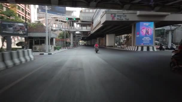 Bangkok Tailandia - 06 de abril de 2020: Biker start from junction under highway with not many cars and motobikes, lockdown Bangkok city due to coronavirus disease COVID-19 pandemic under the highway. — Vídeos de Stock