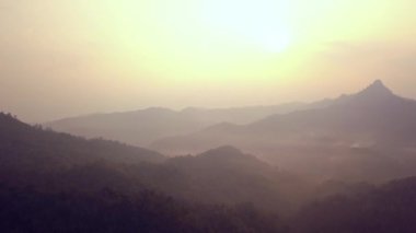 Laos 'ta sabah vahşi orman dağlarının üzerinde güzel bir gündoğumu. Dağların üzerinden uçan hava videosu.