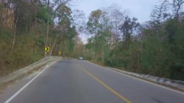 Tayland 'da milli parktaki bir dağ yolunda araba sürüyorum. Sürücü bakış açısı. Arabanın içinden bak, motosikletli POV 4K kamera görüntüsü.