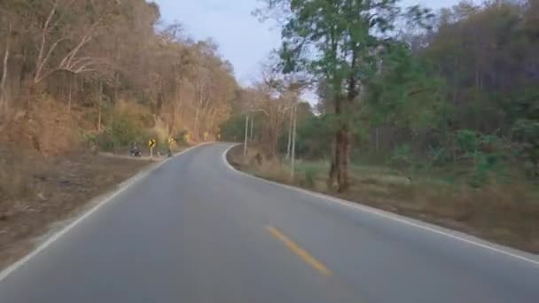 Conducir a lo largo de una carretera montañosa en el parque nacional en Tailandia. Punto de vista de conducción. Vista desde el interior del coche, motobike POV imágenes de conducción 4K — Vídeos de Stock