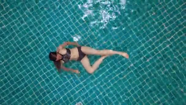 Young woman swimming in open green swimming pool. Outdoor activities. Healthy lifestyle. Top view aerial video 4k. — Stock Video