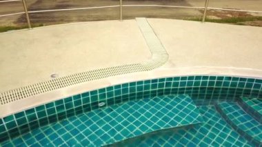 Açık yeşil yüzme havuzunda yüzen genç bir kadın. Açık hava aktiviteleri. Sağlıklı bir yaşam tarzı. Üst görüntü video 4k.