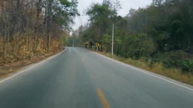 Tayland 'da milli parktaki bir dağ yolunda araba sürüyorum. Sürücü bakış açısı. Arabanın içinden bak, motosikletli POV 4K kamera görüntüsü.