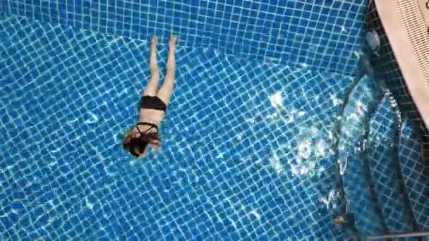 Junge Frau schwimmt im offenen blauen Schwimmbad. Aktivitäten im Freien. Gesunder Lebensstil. Luftbild von oben 4k. — Stockvideo