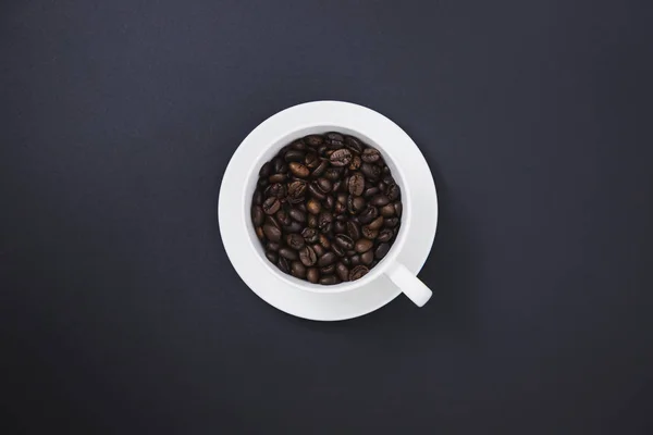Grains de café dans une tasse de café blanc — Photo