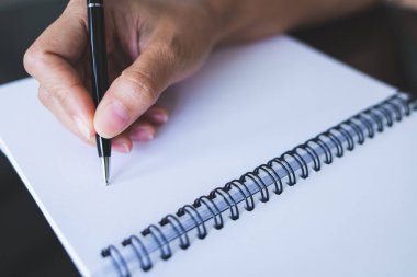 Boş bir üzerine yazmak için siyah bir kalem kullanan kadınların yakın çekim resimleri