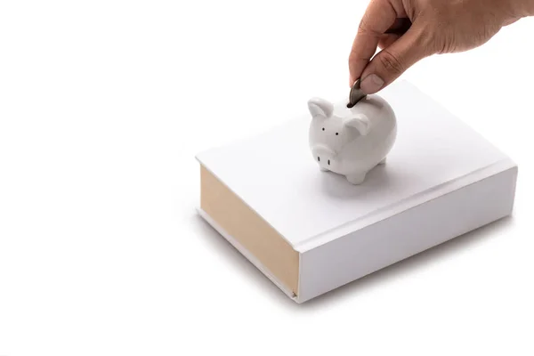 Hand Dropping Coin Piggy Bank Piggy Bank Placed White Book — Stock Photo, Image