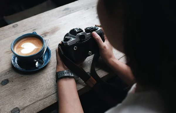 Asyalı Bir Kadın Kahve Dükkanında Oturmuş Film Kamerasıyla Fotoğraf Çekiyor Telifsiz Stok Fotoğraflar