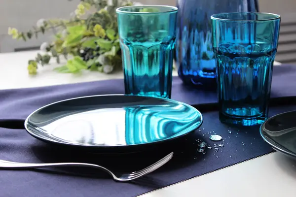 mavi arka plan. Masa mavili ve çatal bıçaklı. Masadaki çatal ve tabak güneş ışığında. Yukarıdan bak. iç ayrıntılar.