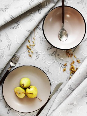 Masa ayarı. Masadaki tabakta sarı armutlar. Yukarıdan görünüşü.